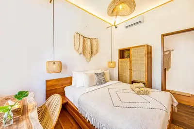 a bedroom with a bed and a table and a mirror at Villa Waikiki - Brand New 4BDR with huge Pool in Seminyak