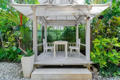a gazebo with a table and chairs in a garden at Villa Rama Sita - 100m from Eat Street, 3BR in Seminyak