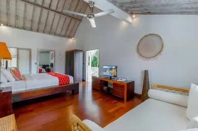a living room with two beds and a television at Villa Rama Sita - 100m from Eat Street, 3BR in Seminyak
