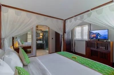 a bedroom with a large bed with a tv on it at Villa Rama Sita - 100m from Eat Street, 3BR in Seminyak