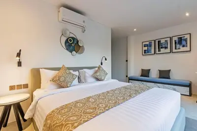 a bedroom with a large white bed and a table at Manresa Villa Bali 4 in Canggu