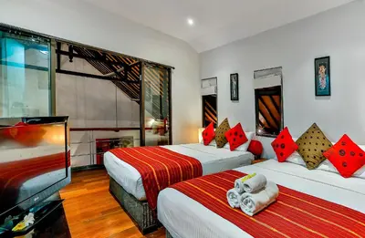 a hotel room with two beds and a television at Villa Taksu Legian in Legian