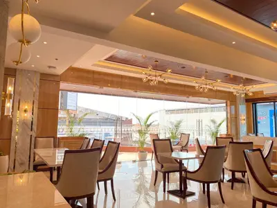 a restaurant with tables and chairs and a large window at City of Aventus Hotel - Denpasar in Denpasar