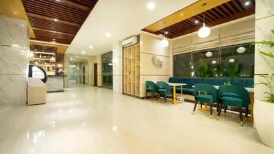 a restaurant with green chairs and a table in a lobby at City of Aventus Hotel - Denpasar in Denpasar