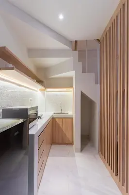 a kitchen with wooden cabinets and a sink at Ellavie Aparthouse Kerobokan in Kerobokan