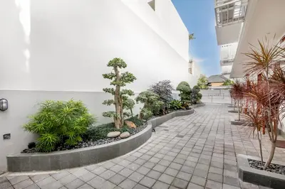a courtyard with trees and plants in a building at Ellavie Aparthouse Kerobokan in Kerobokan