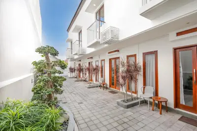 a courtyard of a building with chairs and plants at Ellavie Aparthouse Kerobokan in Kerobokan
