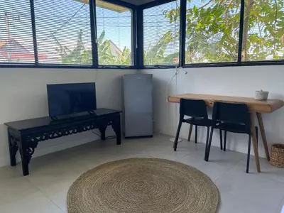 a living room with a table and a table and chairs at The Drupadi Apartments Studio Gordy in Seminyak