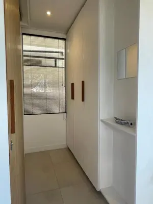 a hallway with white cabinets and a window at The Drupadi Apartments Studio Gordy in Seminyak