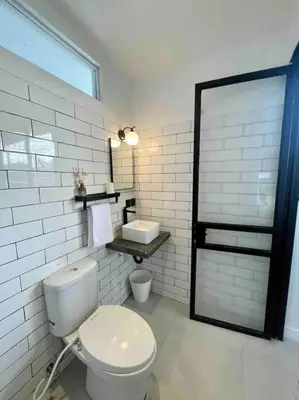 a white bathroom with a toilet and a sink at The Drupadi Apartments Studio Gordy in Seminyak
