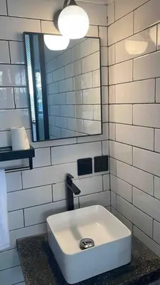 a bathroom with a sink and a mirror at The Drupadi Apartments Studio Gordy in Seminyak