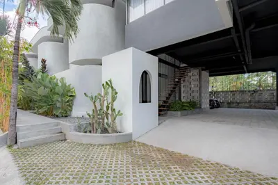 a building with a courtyard with plants and a staircase at The Drupadi Apartments Studio Gordy in Seminyak