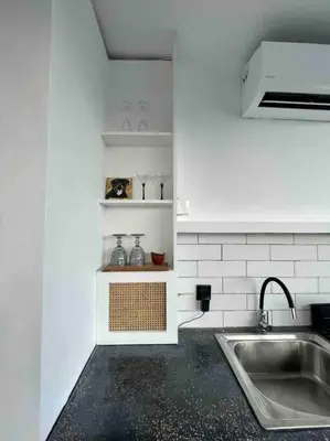 a white kitchen with a sink and a counter at The Drupadi Apartments Studio Gordy in Seminyak