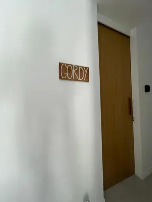 a company sign on a wall next to a door at The Drupadi Apartments Studio Gordy in Seminyak