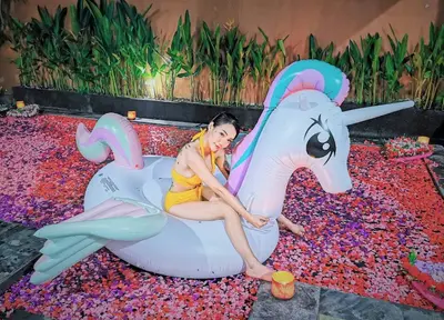 a woman sitting on a unicorn ride at a party at Private Pool Villas Kuta Bali in Kuta