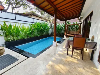 a swimming pool in a yard with a table and chairs at Private Pool Villas Kuta Bali in Kuta