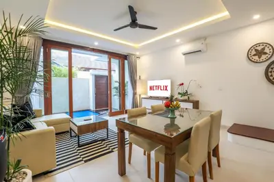 a living room with a dining room table and chairs at Vienna Villas by Great Bali Villas in Seminyak