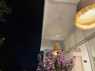 a chandelier and some purple flowers in a room at Capricorn Villa in Seminyak