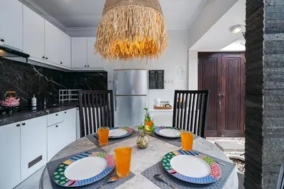a kitchen with a table with plates on it at Villa Putih Jimbaran in Jimbaran