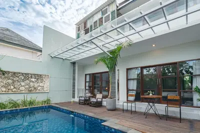 a villa with a swimming pool and a house at Villa Putih Jimbaran in Jimbaran