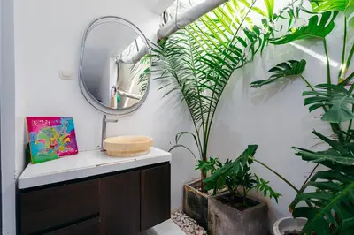 a bathroom with plants and a mirror and a sink at Villa Putih Jimbaran in Jimbaran