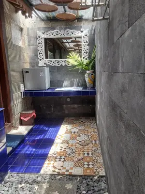 a bathroom with a sink and a mirror on the wall at Buratwangi Joglo House in Kerobokan