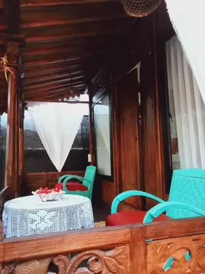 a table and chairs in a room with a white table and chairs at Buratwangi Joglo House in Kerobokan