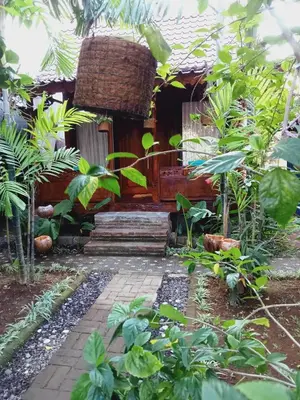 a house in the middle of a garden at Buratwangi Joglo House in Kerobokan