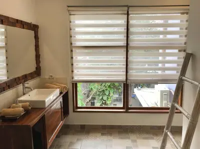 a bathroom with a window with a sink and a mirror at 2 BR Pepper House Villa near GWK Jimbaran - garden view in Jimbaran