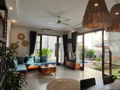a living room with a blue couch and a table at 2 BR Pepper House Villa near GWK Jimbaran - garden view in Jimbaran