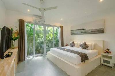 a bedroom with a large bed and a large window at Villa Becca 4 Bedroom at Seminyak near to the Beach in Seminyak
