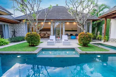 a swimming pool in front of a house at Villa Becca 4 Bedroom at Seminyak near to the Beach in Seminyak