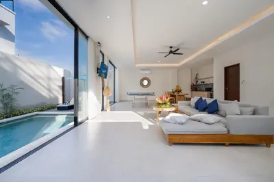 a living room with a couch and a swimming pool at Canggu Villa Go by Nagisa Bali in Canggu