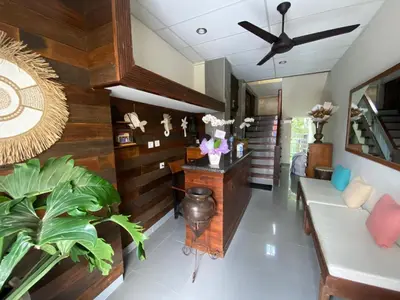 a living room with wooden walls and a ceiling fan at Alu Lofts in Seminyak