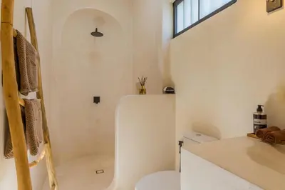 a white bathroom with a toilet and a sink at VILLA SALEYA with JACUZZI in Canggu