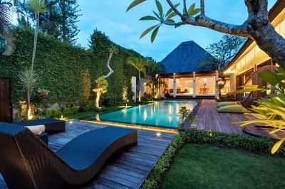a backyard with a swimming pool and a house at Navya Villas in Canggu
