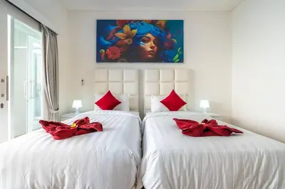 a bedroom with two beds with red bows on them at Luxury minimalist villa Nobu in Seminyak in Seminyak