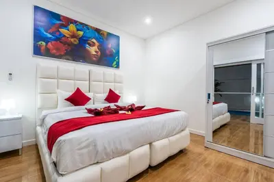 a bedroom with a large white bed with red pillows at Luxury minimalist villa Nobu in Seminyak in Seminyak