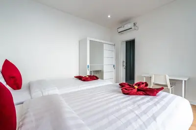 a bedroom with a white bed with red bows on it at Luxury minimalist villa Nobu in Seminyak in Seminyak