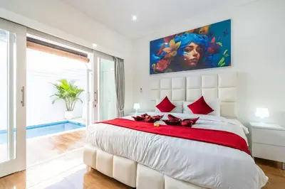 a bedroom with a large white bed with red pillows at Luxury minimalist villa Nobu in Seminyak in Seminyak