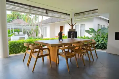a dining room table and chairs in a house at Kerta Rama Seminyak by Kerta Living in Seminyak