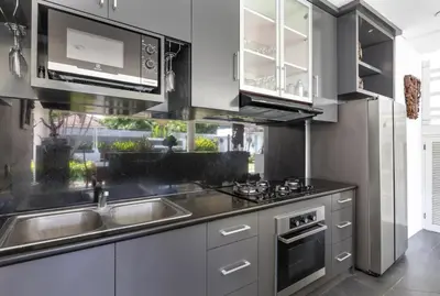 a kitchen with a sink and a microwave at Kerta Rama Seminyak by Kerta Living in Seminyak