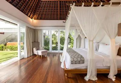 a bedroom with a bed with a canopy at Kerta Rama Seminyak by Kerta Living in Seminyak