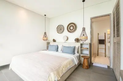 a white bedroom with a large bed and pendant lights at Chic 4BR Villa, Canggu Hub, 800m to Beach Bliss in Canggu