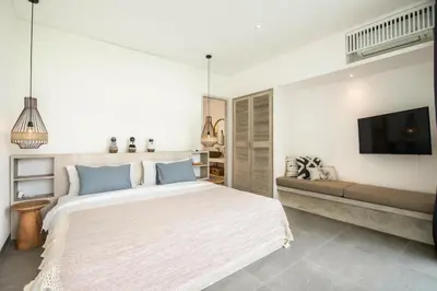 a bedroom with a large bed and a flat screen tv at Chic 4BR Villa, Canggu Hub, 800m to Beach Bliss in Canggu