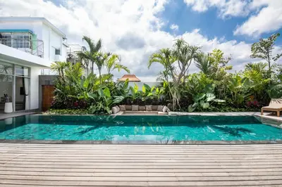 a swimming pool in front of a house at Chic 4BR Villa, Canggu Hub, 800m to Beach Bliss in Canggu