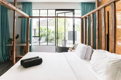 a bedroom with a white bed and a large window at Villa Ruku-Ruku - Modern 1BR Villa with AC Living Room & Private Pool - French Style Interior in Kerobokan