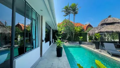 a swimming pool next to a building with a resort at Villa Ruku-Ruku - Modern 1BR Villa with AC Living Room & Private Pool - French Style Interior in Kerobokan