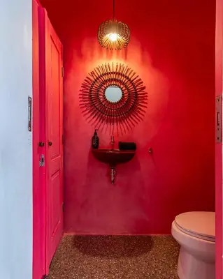 a bathroom with a red wall with a sink and a mirror at Villa Ruku-Ruku - Modern 1BR Villa with AC Living Room & Private Pool - French Style Interior in Kerobokan