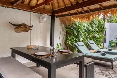 a dining table and chairs on a patio at Villa Ruku-Ruku - Modern 1BR Villa with AC Living Room & Private Pool - French Style Interior in Kerobokan